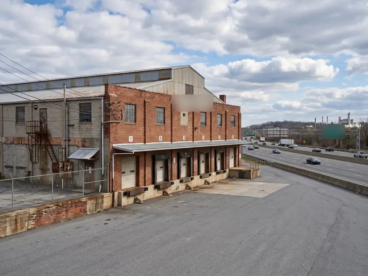 Older brick industrial building next to a highway